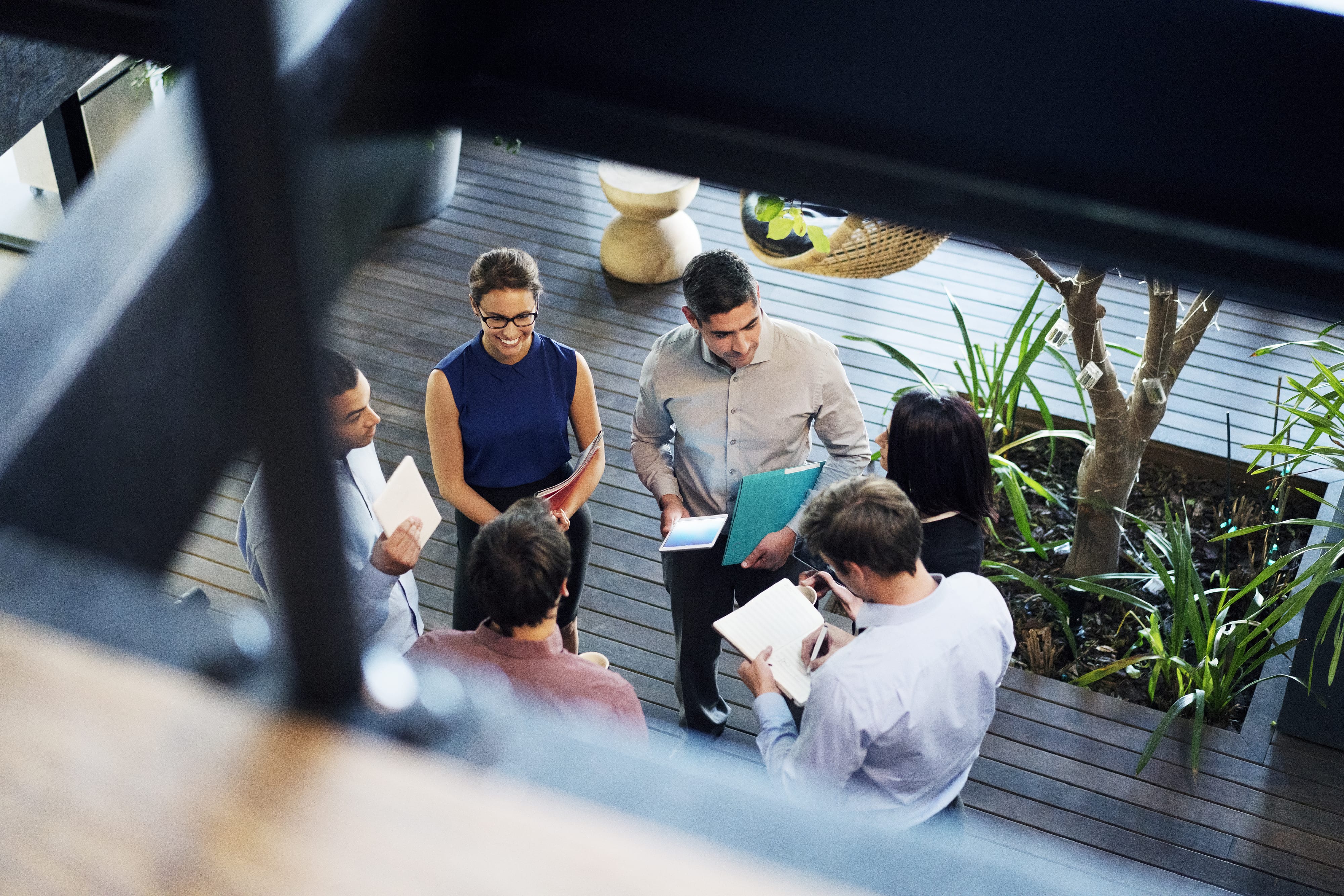 A group of consultants and clients standing in a circle discussing possible solutions