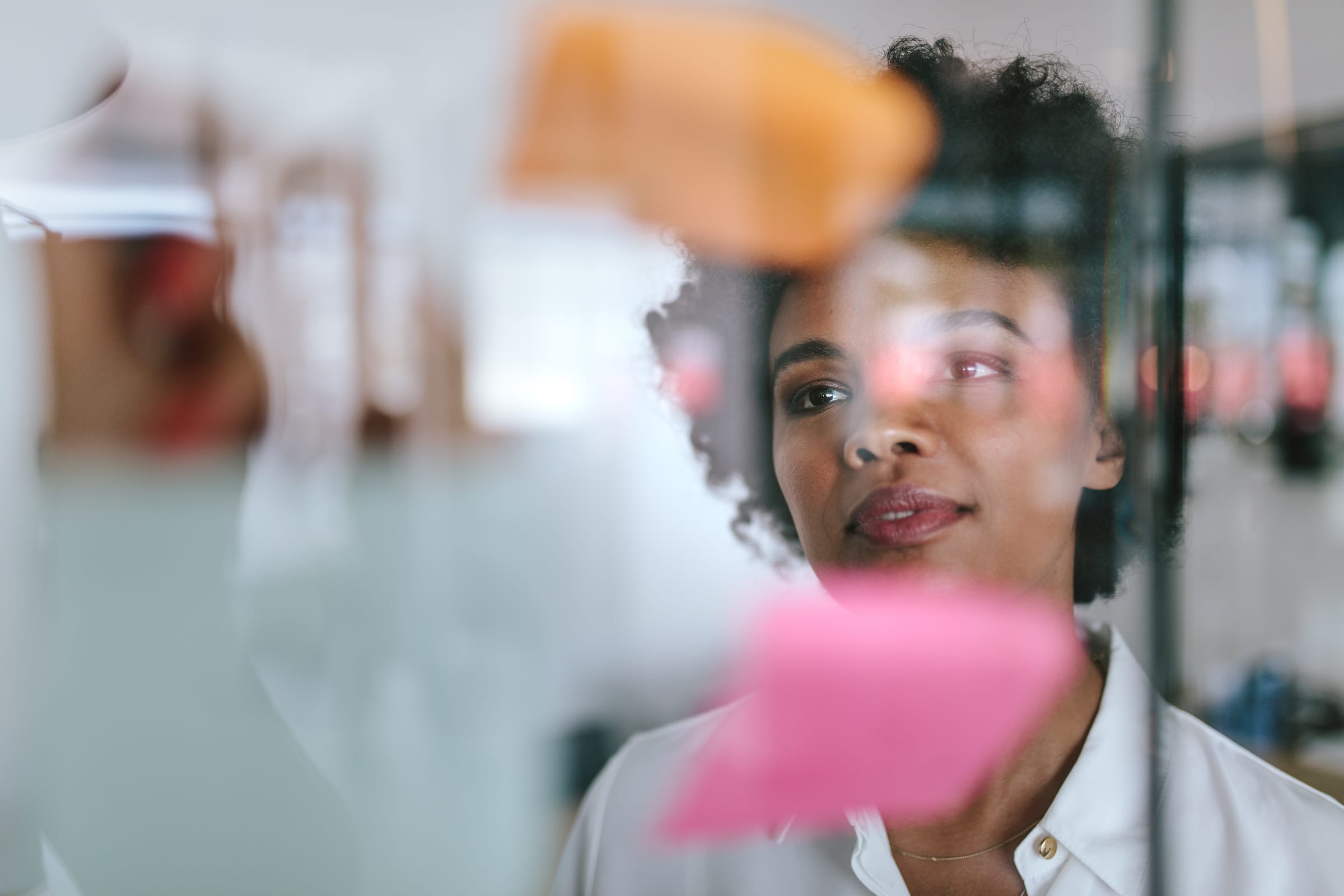 Woman looking at a window covered with post-it notes