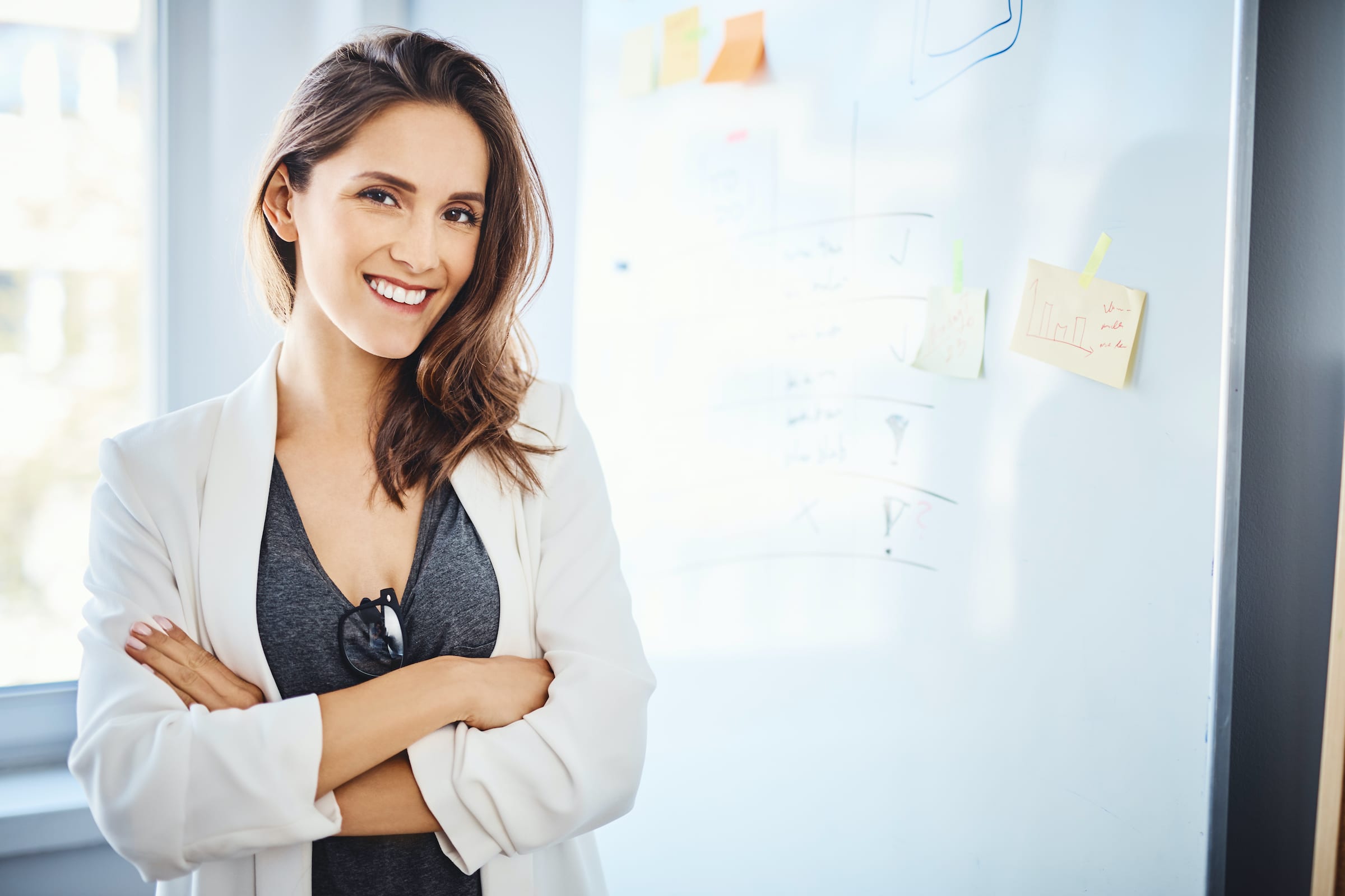 A female digital strategist standing in front of whiteboard with post-it notes